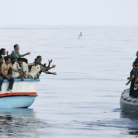 Armed Forces of Malta marines toss bottles of water to a group of around 180 illegal immigrants as a rescue operation gets underway after their vessel ran into engine trouble, some 30km (19 miles) southwest of Malta in this September 25, 2005 file photo. As many as 900 people may have died in Sunday's disaster off the coast of Libya. That would be the highest death toll in recent times among migrants, who are trafficked in the tens of thousands in rickety vessels across the Mediterranean. The mass deaths have caused shock in Europe, where a decision to scale back naval operations last year seems to have increased the risks for migrants without reducing their numbers. The European Union has proposed doubling the size of its Mediterranean search and rescue operations in response to the crisis.  REUTERS/Darrin Zammit Lupi/Files   MALTA OUT. NO COMMERCIAL OR EDITORIAL SALES IN MALTA  TPX IMAGES OF THE DAY  PICTURE 02 OF 28 FOR WIDER IMAGE STORY 'ISLE LANDERS' SEARCH 'DARRIN ISLE' FOR ALL IMAGES